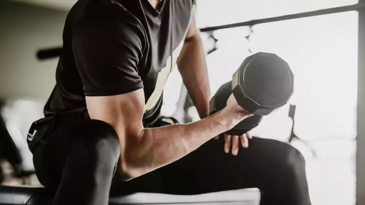 Un homme réalisant un curl biceps. 