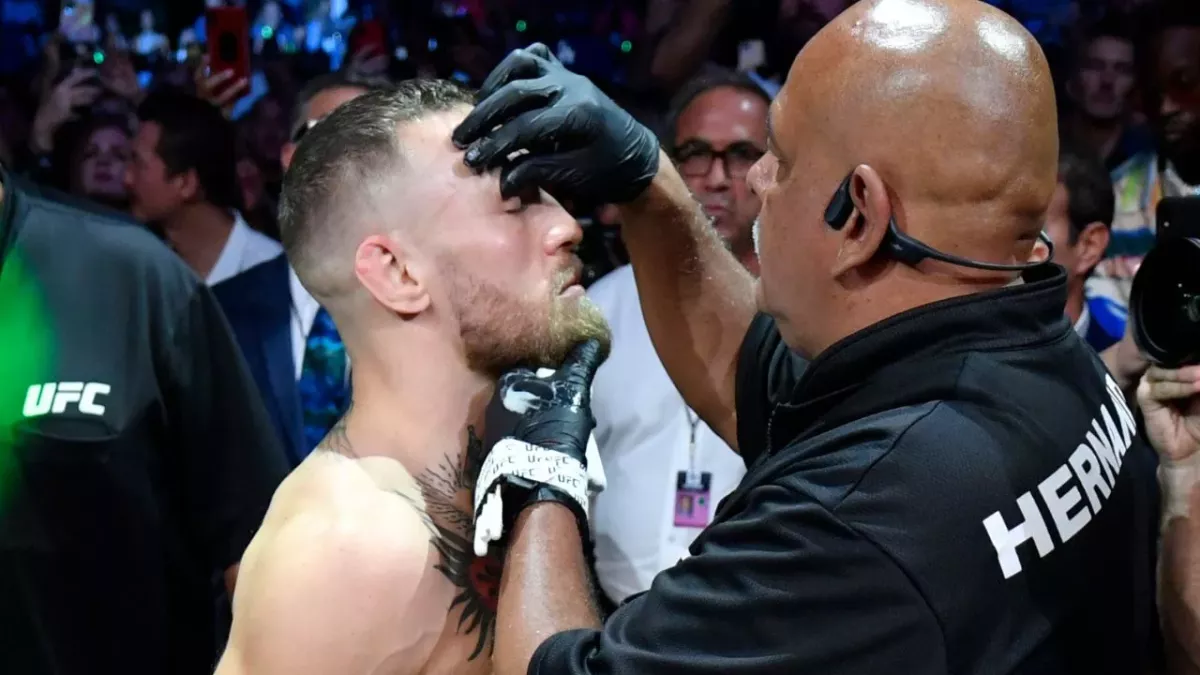 Conor McGregor recevant de la vaseline sur son visage avant de monter dans l'octogone. 