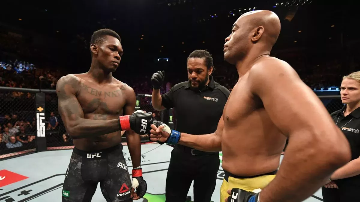 Israel Adesanya et Anderson Silva dans l'octogone lors de leur combat à l'UFC en 2019. 
